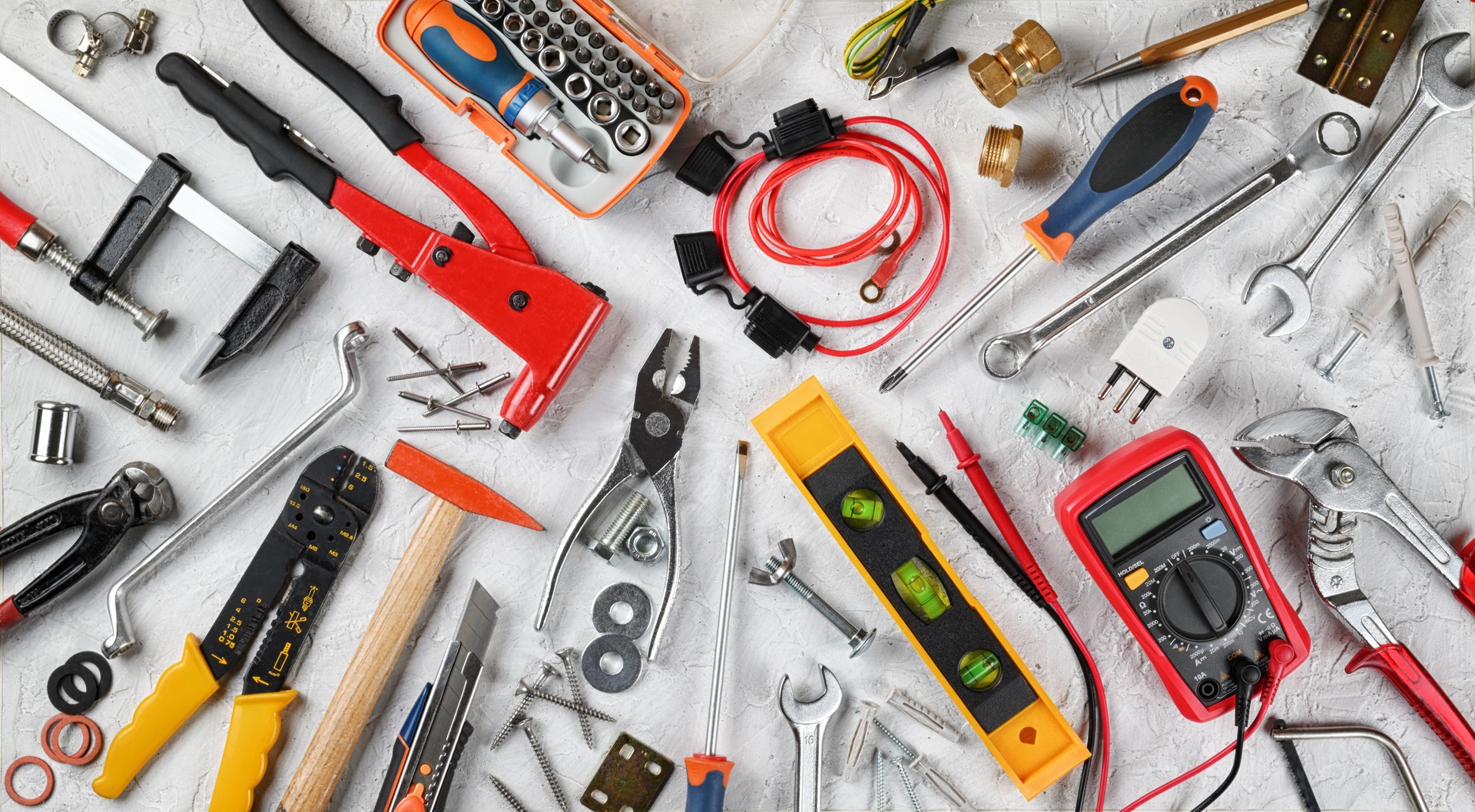 Set of hand tools on white plaster background. Work tools for electrician, carpenter, mechanic, plumber and hobist. Top view, flat lay.